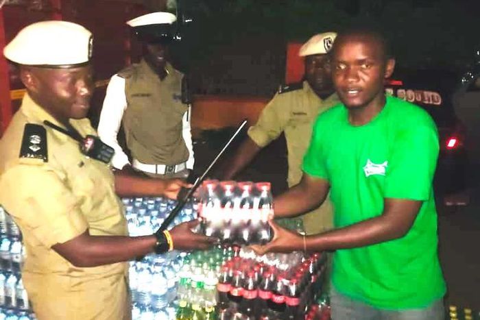 SSP Rogers Nsereko Kauma, the Kampala Metropolitan Traffic Police Commander recieving the refreshementfrom CCBU's Kirunda Magoola