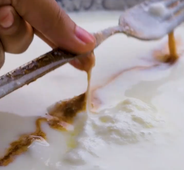 The lactic acid in the milk acts on the rust