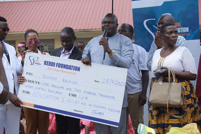 Stephen Keddi, the founder of Keddi Foundation handing out the dummy cheque at the school