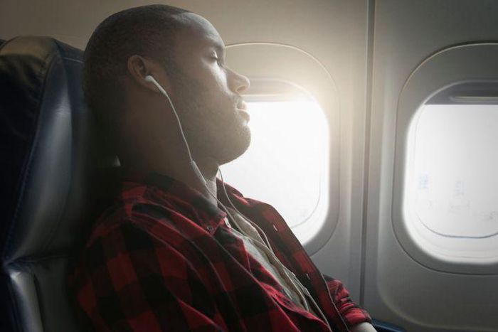 Black man sleeping on a plane [Getty/Jose Luis Pelaez]
