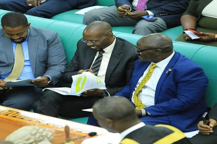Works Minister, Katumba Wamala (R), deputy attorney general Jackson Kafuuzi (C), and Committee Chairperson Dan Kimisho confer during the debate on the bill