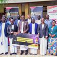 NBL Head of Legal and Corporate Affairs, Mr Emmauel Njuki (3rd left) handing over the dummy check to Busoga PM Muvawala