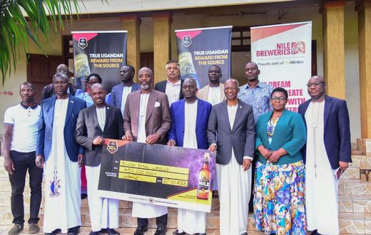 NBL Head of Legal and Corporate Affairs, Mr Emmauel Njuki (3rd left) handing over the dummy check to Busoga PM Muvawala