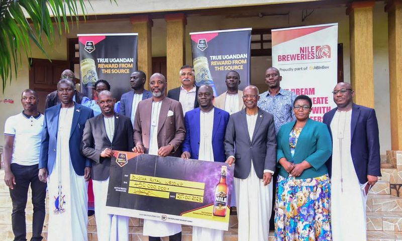 NBL Head of Legal and Corporate Affairs, Mr Emmauel Njuki (3rd left) handing over the dummy check to Busoga PM Muvawala