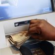 A woman takes Nigerian Naira from a bank's automated teller machine (ATM) in Ikeja district in the commercial capital Lagos November 12, 2014.