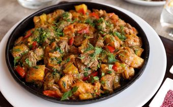 Beef stew garnished with cilantro [Image Credit: Valeria Boltneva]