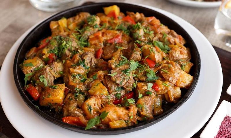 Beef stew garnished with cilantro [Image Credit: Valeria Boltneva]