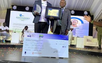 Ssentogo posing with his award. Besides him is the Iganga District Resident Judge, Justice David Batema