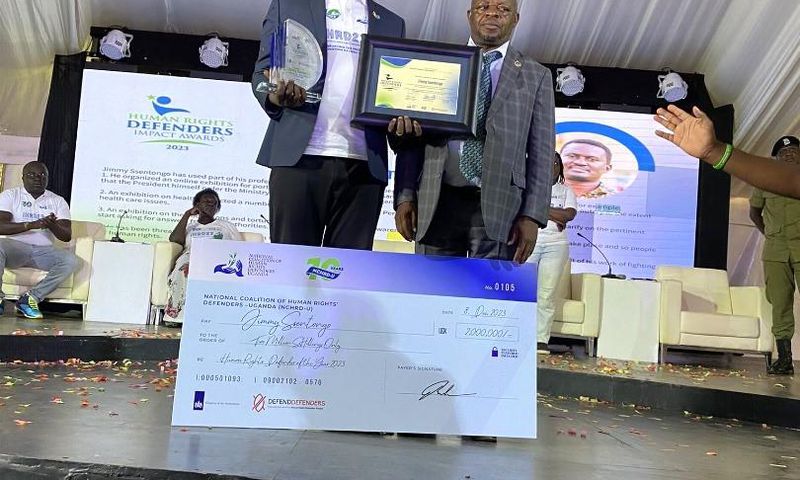 Ssentogo posing with his award. Besides him is the Iganga District Resident Judge, Justice David Batema