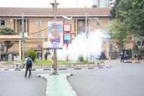 A journalist stares at a launched tear gas