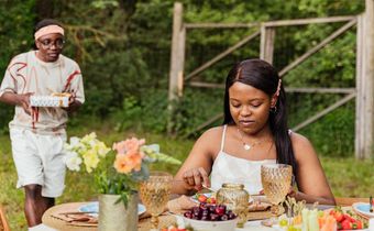 Couple on an outdoor date with the man holding a surprise gift [Image Credit: Antoni Shkraba Production]