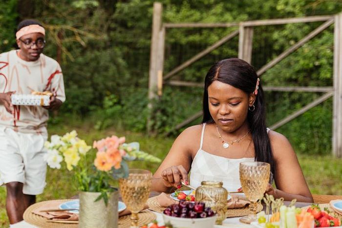 Couple on an outdoor date with the man holding a surprise gift [Image Credit: Antoni Shkraba Production]