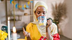 Woman in yellow hijab eating and drinking during Ramdhan [Image Credit: RDNE Stock Project]