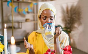 Woman in yllow hijab eating and drinking during Ramdhan [Image Credit: RDNE Stock Project]