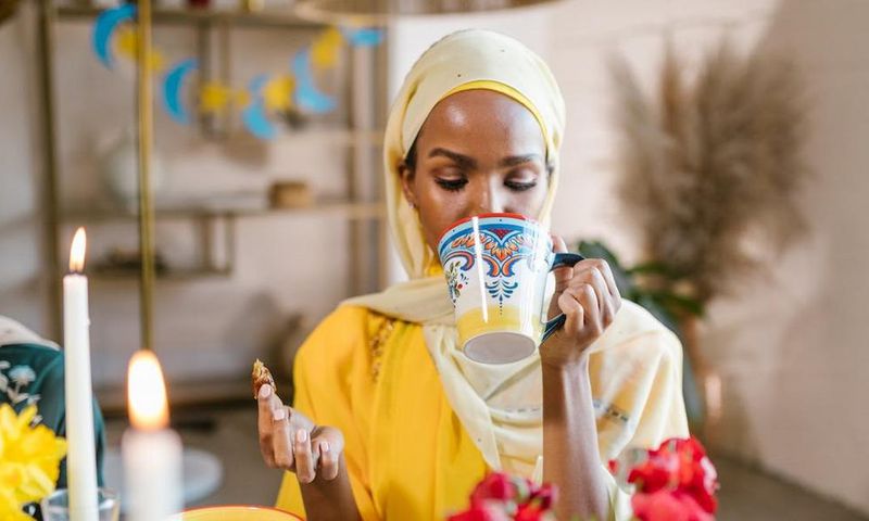 Woman in yllow hijab eating and drinking during Ramdhan [Image Credit: RDNE Stock Project]