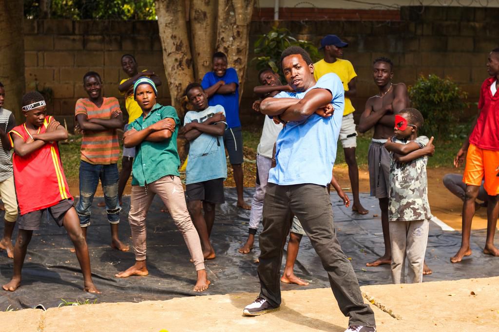 teaching breakdance to teenage boys who are former street children