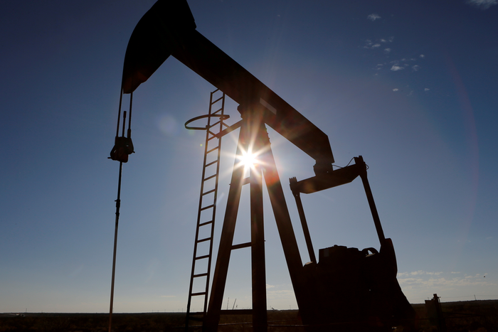FILE PHOTO: The sun is seen behind a crude oil pump jack in the Permian Basin in Loving County, Texas, U.S., November 22, 2019. REUTERS/Angus Mordant