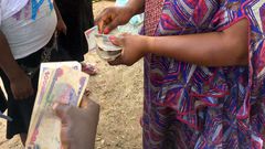 Women collecting money [Premium Times Nigeria]