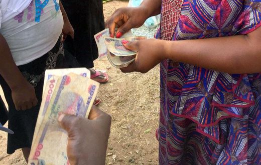 Women collecting money [Premium Times Nigeria]