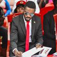 Bobi Wine signing the eulogies book