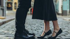Couple standing on cobblestone street [Image Credit: Aljona Ovtšinnikova]
