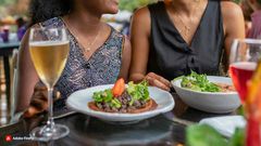 Firefly Women talking at a restaurant in Kenya One is laughing, one is looking down 6696
