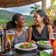 Firefly Women talking at a restaurant in Kenya One is laughing, one is looking down 6696