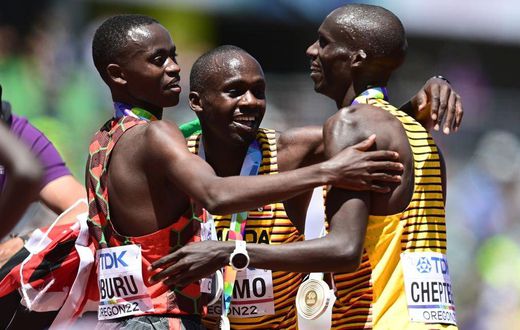 EUGENE, OREGON - JULY 17: Gold medalist Joshua Cheptegei of Team Uganda, silver medalist Stanley Waithaka Mburu of Team Kenya and bronze medalist Jacob Kiplimo of Team Uganda celebrate after the Men's 10,000m Final on day three of the World Athletics C...