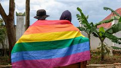 A gay Ugandan couple cover themselves with a pride flag as they pose for a photograph in Uganda Saturday, March 25, 2023.AP Photo