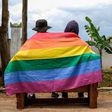 A gay Ugandan couple cover themselves with a pride flag as they pose for a photograph in Uganda Saturday, March 25, 2023.AP Photo
