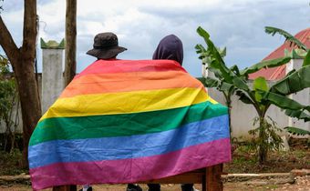 A gay Ugandan couple cover themselves with a pride flag as they pose for a photograph in Uganda Saturday, March 25, 2023.AP Photo