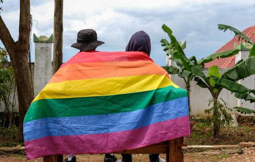 A gay Ugandan couple cover themselves with a pride flag as they pose for a photograph in Uganda Saturday, March 25, 2023.AP Photo