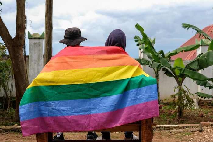 A gay Ugandan couple cover themselves with a pride flag as they pose for a photograph in Uganda Saturday, March 25, 2023.AP Photo