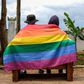 A gay Ugandan couple cover themselves with a pride flag as they pose for a photograph in Uganda Saturday, March 25, 2023.AP Photo