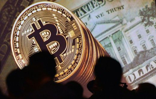 A screen displays images of Bitcoin and US dollars at the Interpol World Congress in Singapore on July 4, 2017