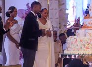 Namusoke stands behind the newlyweds during the cake cutting