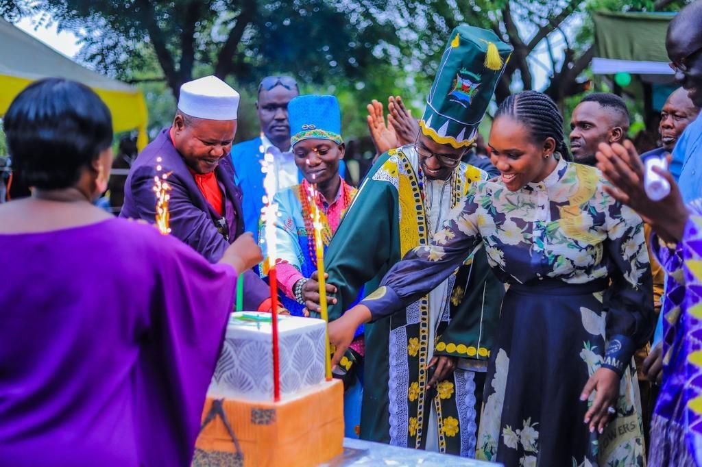 Minister Nyamutoro cuts cake with Rwoth Stanley Thoopachu Ombidi III