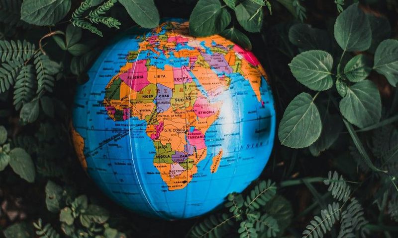 Globe in green leaves with map of Africa in view [Photo: Nothing Ahead]