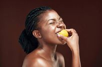 Photo of an attractive young woman eating a lemon