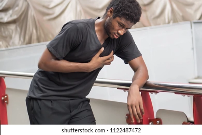 A stock photo of someone posing like they suffered a heart attack