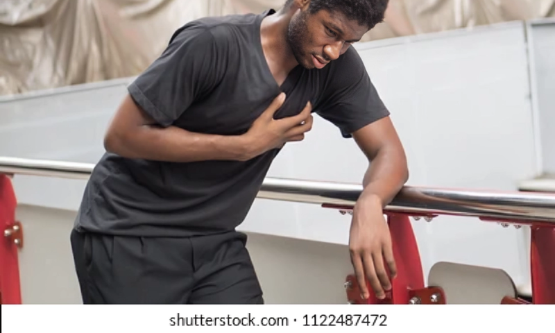 A stock photo of someone posing like they suffered a heart attack