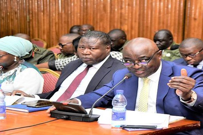 Ssempijja (R) appearing before the Committee on Defence and Internal Affairs. On his right are State Ministers Oboth Oboth and Huda Oleru.