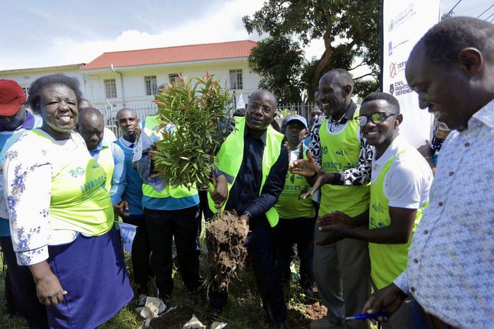 Kyakulya (centre) planting a tree to mark Human Rights Defenders Day. Photos by Ambrose Watanda