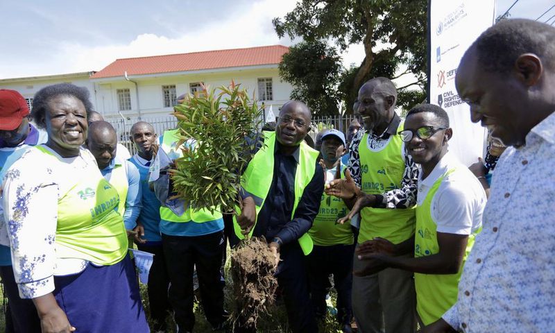 Kyakulya (centre) planting a tree to mark Human Rights Defenders Day. Photos by Ambrose Watanda