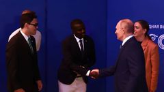 Davis Akampulira shakes hands with Russian President Vladimir Putin