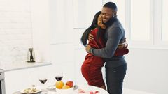 Man and woman hugging and Valentine dinner with wine on table [Image Credit: Gustavo Fring]