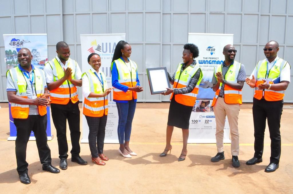 Minister Evelyn Anite handing over the investment license to Bar Aviation officials