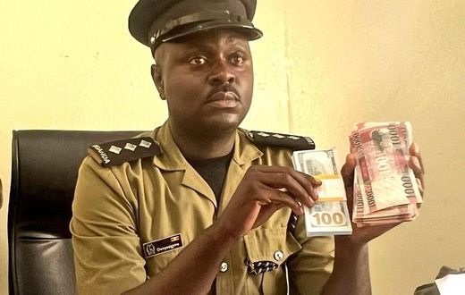 Luke Owoyesigire showing some of the counterfeit money seized in the police operation