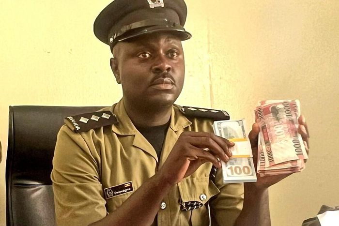 Luke Owoyesigire showing some of the counterfeit money seized in the police operation