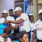 Ministry of Health Spokesperson Mr. Emmanuel Ainebonya, Group Chief Category and Innovations Officer Mrs Toluwaleke and Head of Marketing and Corporate Affairs, Mr. Robert Kitenda (C) handing over the items to young mothers at Kawempe National Referral...
